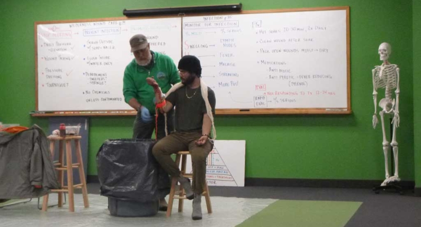 Two people appear in front of a large white board while participating in a WFR course. 